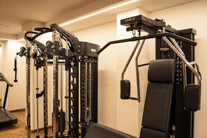 A gym with a variety of exercise equipment, including a cable machine and weight stack.