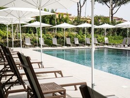 A poolside area with lounge chairs and umbrellas.