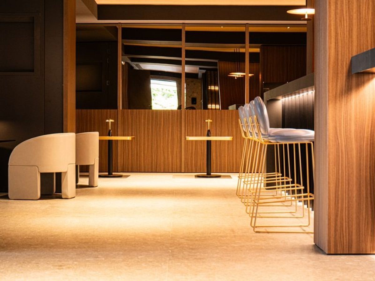 Un intérieur moderne avec un espace bar, des sièges et une vue dégagée grâce à une cloison en bois.