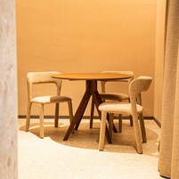 Una esquina de una habitación con una mesa redonda y cuatro sillas.