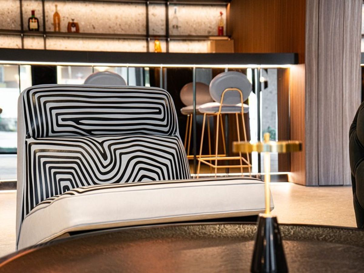Ein modernes Wohnzimmer mit einem einzigartigen schwarz-weißen Sofabezug, einem modernen Couchtisch und einer stilvollen Bar mit Glastrennwand.
