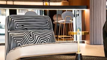 Ein modernes Wohnzimmer mit einem einzigartigen schwarz-weißen Sofabezug, einem modernen Couchtisch und einer stilvollen Bar mit Glastrennwand.