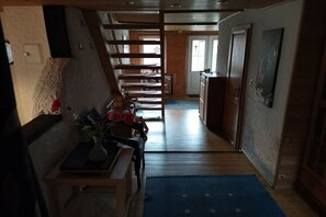 A hallway with a wooden staircase, a dining area, and a kitchen. - Holiday home with 4 bedrooms (Sankt Andreasberg)