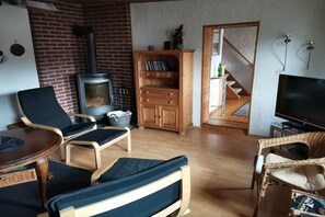 A cozy living room with a fireplace, a television, and comfortable seating. - Holiday home with 4 bedrooms (Sankt Andreasberg)
