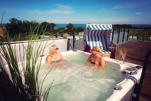 Ein Whirlpool für zwei Personen, umgeben von einer Terrasse und Blick aufs Meer.