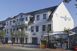 Een wit gebouw met een bord waarop 'HEIMATHAFEN' staat en een balkon.