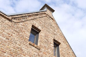 A corner of a building with a brick facade and two windows. - "Sun Garden" in the little house on the Rhine (Rees)