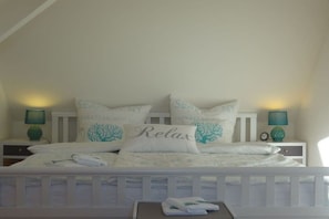 A bedroom with a bed, pillows, a nightstand, and a lamp. - Holiday apartment with 1 bedroom (Hasselberg)
