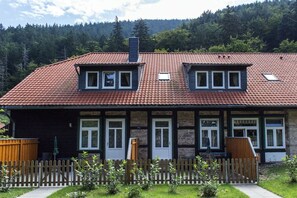 A two-story house with a tiled roof, a wooden fence, and a garden. - in the forester's lodge on the Brocken mountain - 2 bedrooms (Ilsenburg)