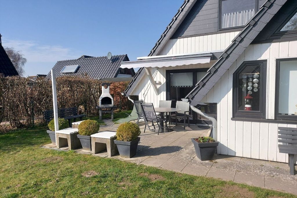 A residential property with a patio area, outdoor seating, and a small garden.