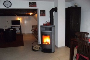 A cozy living room with a fireplace, a television, and a dining area. - Holiday home with 2 bedrooms (Butjadingen - Burhave)