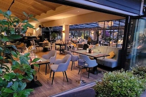Ein modernes Interieur mit Sitzgelegenheiten, einer Bar und großen Fenstern mit Blick.