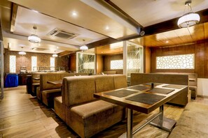 Ein Restaurant mit Holzböden, gepolsterten Sitzecken und einem zentralen Tisch mit Tischsets.