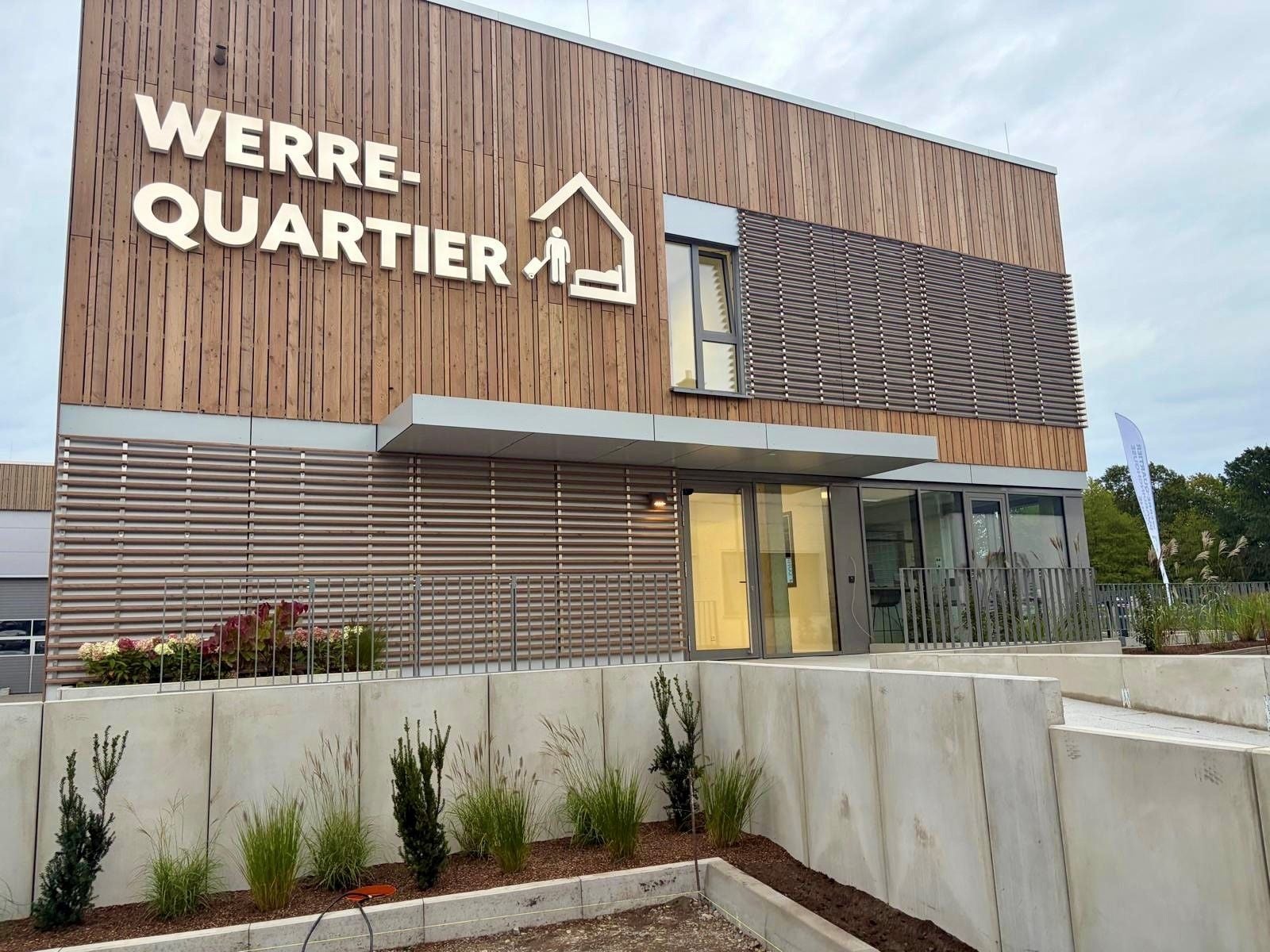 A modern building with a sign reading 'WERRE-QUARTIER' and a glass entrance.