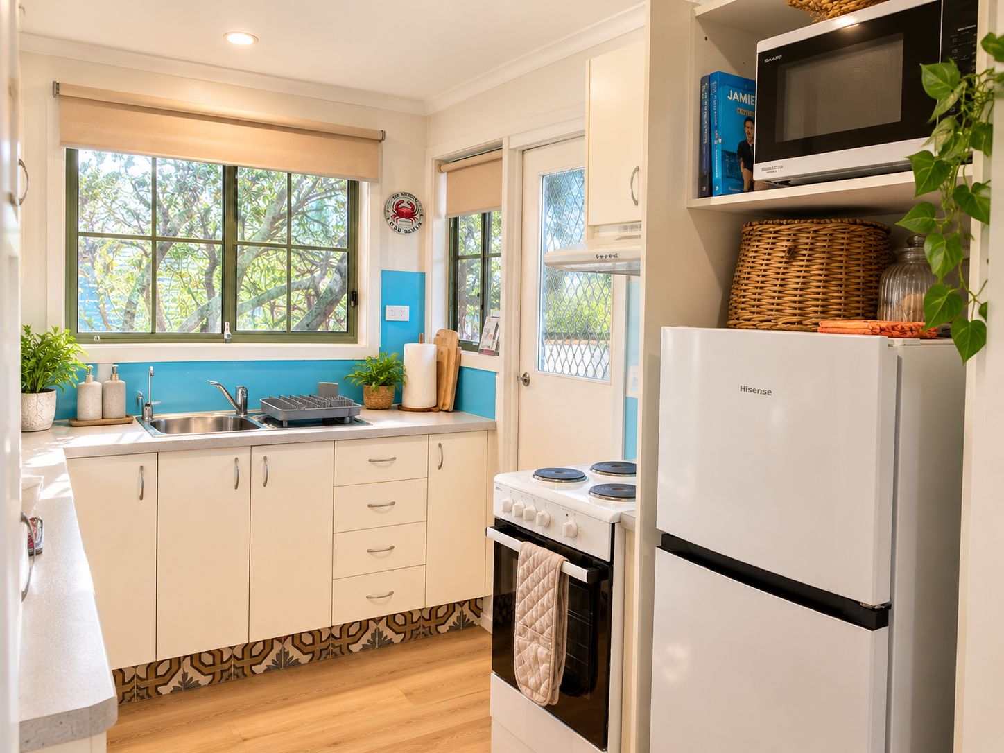 A kitchen with white cabinets, a stove, a microwave, and a refrigerator.