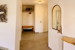 A hallway with a bench, a door, and a mirror on the wall. - Holiday apartment with 2 bedrooms (Cuxhaven)