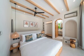 A modern bedroom with a large bed, ceiling fan, and artwork on the wall. - Modern Tropical Villas in Bingin (Bingin)