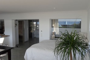 Ein Schlafzimmer mit einem Bett, einem Schreibtisch und einem Fenster mit Blick.