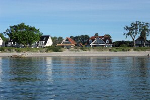 Eine Wohngegend am Seeufer mit Häusern direkt am Strand und ruhigem Wasser.