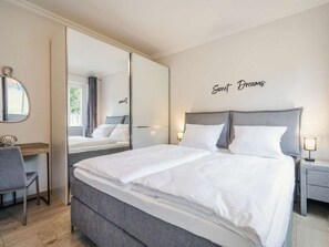 Ein Hotelzimmer mit einem großen Bett, einem Schreibtisch und einem Spiegel.