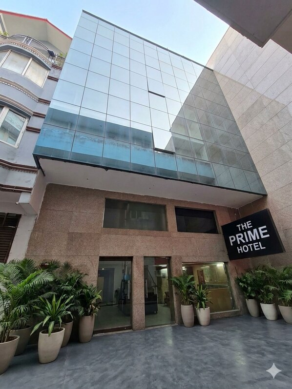 A hotel entrance with a modern glass facade, a sign reading 'The Prime Hotel,' and potted plants in front. - Hotel The Prime Near Aerocity New Delhi (New Delhi)