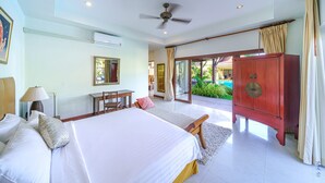 Ein Hotelzimmer mit Bett, Schreibtisch und Blick auf einen Swimmingpool.