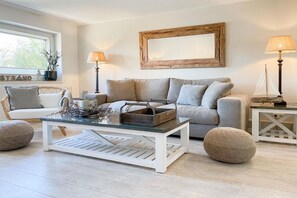 A living room with a sofa, two lamps, a coffee table, and a framed picture on the wall. - Holiday home with 3 bedrooms (Timmendorfer Strand)