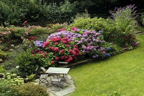 A garden with a variety of flowers and a table with chairs. - Holiday apartment with 2 bedrooms (Scharbeutz)