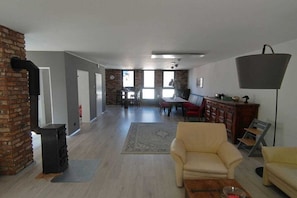 A spacious living area with a fireplace, a dining table, and a sofa. - Holiday home in Remagen with barbecue (Remagen)
