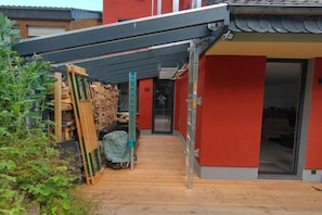 A narrow wooden pathway leading to a building with a red exterior and a grey roof. - Holiday home in Remagen with barbecue (Remagen)