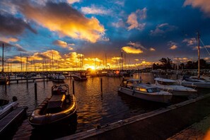 A marina with boats docked at the pier during sunset. - Penthouse First Line (Damp)