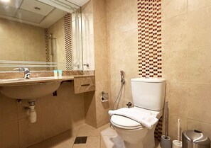 Ein Badezimmer mit Waschbecken, Spiegel, Toilette und einer Wand mit Muster.