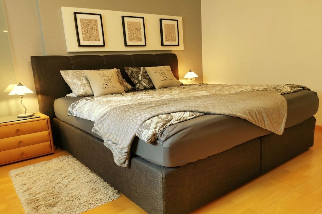 A bedroom with a bed, bedside tables, and wall-mounted artwork. - Holiday apartment with 1 bedroom (Borken)