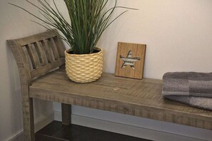 Un banc en bois sur lequel est posé un pot en osier et une décoration en forme d’étoile.