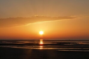 A sunset over a beach with calm waters reflecting the sun. - HUS PIA Apt. 1 "Helgoland" (Cuxhaven)