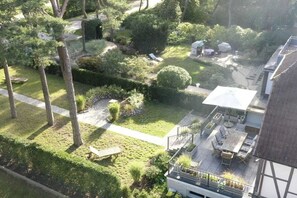 A residential property with a well-maintained garden, outdoor seating area, and a balcony with a table and chairs. - Holiday home with 1 bedroom (Timmendorfer Strand)