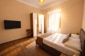 A bedroom with a bed, a television, a chair, and a wardrobe. - Casa Dolce Casa Elegant Penthouse (Roma)