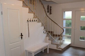 Eine Treppe mit einer weißen Handläufe und einer weißen Sitzbank am Fuß.