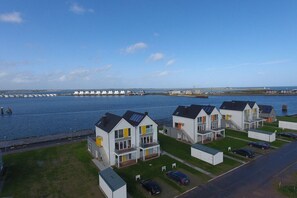 Ein Küstenwohngebiet mit modernen Häusern, einem Yachthafen und freiem Blick auf das Meer.