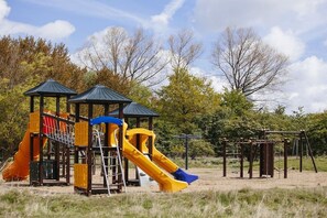 Ein Spielplatz mit Rutschen und Klettergerüsten.