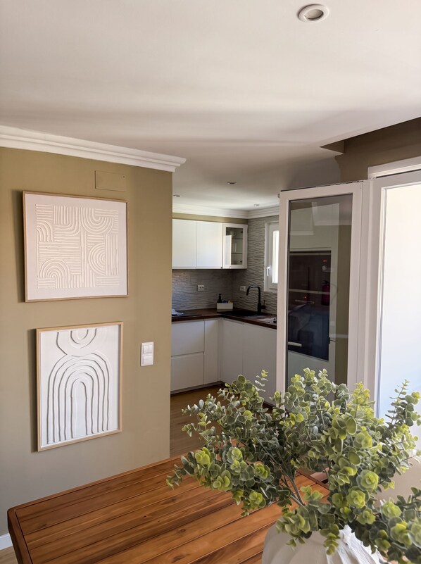 A modern kitchen with white cabinets, a black faucet, and a window. - One-bedroom apartment with a view of Marina Vilamoura (Quarteira)