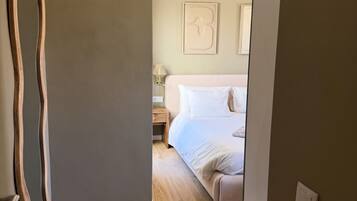A bedroom with a bed, a nightstand, and a wall-mounted lamp.