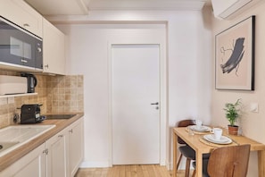 A compact kitchen with a microwave, coffee maker, and toaster on the countertop. - Lovely apartment with AC - Center of Paris (Paris)