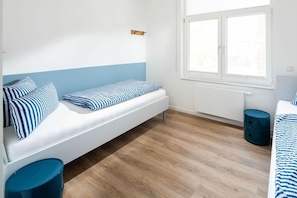 Ein Zimmer mit einem Bett, einem Fenster und einer Heizung.