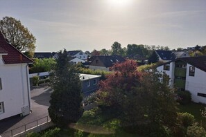 Een woonwijk met huizen, een boom en een heldere lucht.
