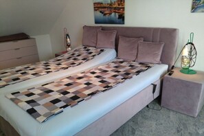 Ein Schlafzimmer mit einem Bett, einem Schminktisch, einem Nachttisch und einer Wandlampe.