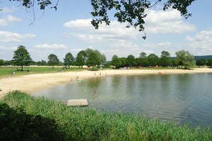 A lakeside park with a sandy beach and a wooden dock. - Holiday apartment with 2 bedrooms (Beverungen)