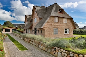 A house with a unique architectural style, featuring a steeply pitched roof and brick construction. - Luxury homes Sylt Ubuntu (Wenningstedt \/ Braderup)