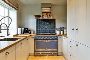 A kitchen with a built-in stove, a sink, and a window. - Luxury homes Sylt Ubuntu (Wenningstedt \/ Braderup)