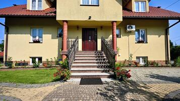 Ein zweistöckiges Haus mit Eingangsbereich, einer Treppe und einem Garten.